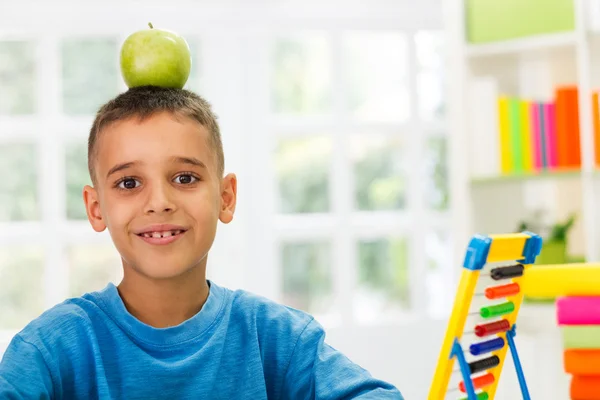 Kind bestuderen en zijn appel in hoofd — Stockfoto