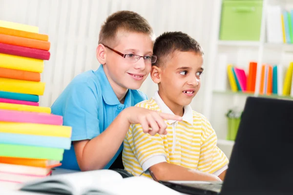 两个小男孩在家里看着笔记本电脑 — 图库照片