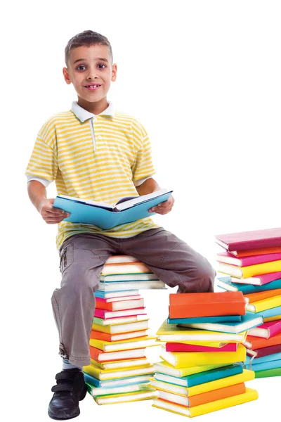 Chlapec seděl na hromadě knih a učit se — Stock fotografie