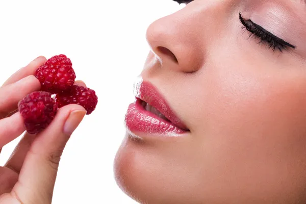 Young beautiful woman eating raspberries — Stock Photo, Image