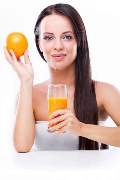 Mujer joven sosteniendo jugo de naranja y naranja — Foto de Stock