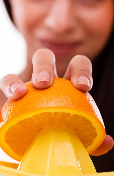 Mujer aprieta una naranja — Foto de Stock