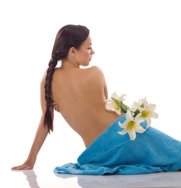 Bela mulher com toalhas de spa azuis em branco — Fotografia de Stock