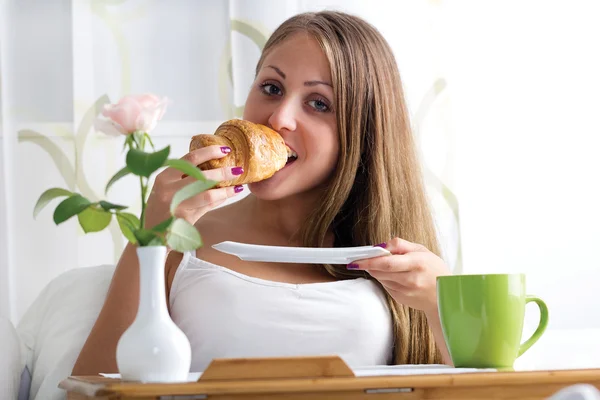 Kvinna äter frukost i sängen — Stockfoto