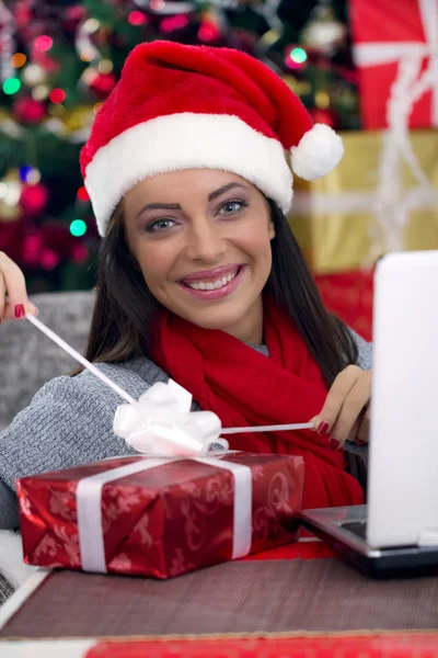 Mulher abrindo um presente na noite de Natal — Fotografia de Stock