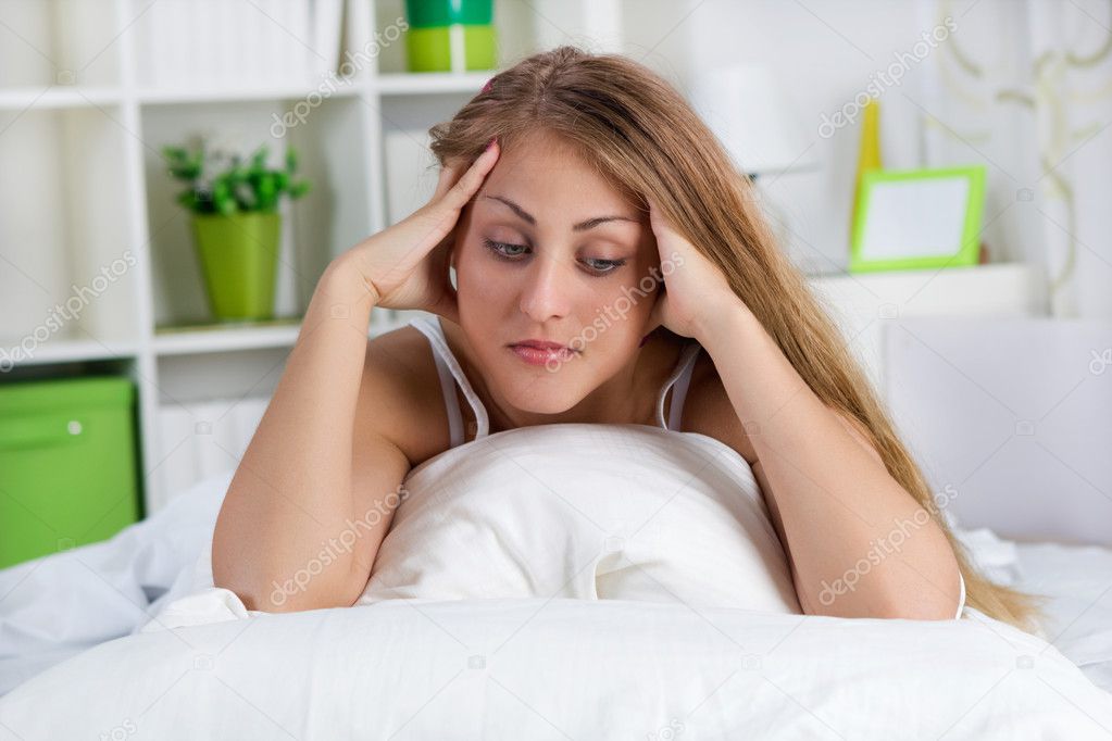 lonely young woman lying in bed
