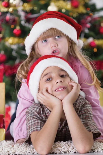 Portrait of happy boy laughing in his sister embrace on Christma — Stock Photo, Image