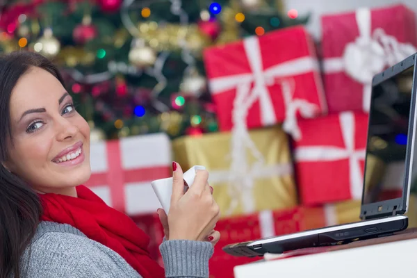 Kobieta korzysta z laptopa na Boże Narodzenie noc pić kawę — Zdjęcie stockowe