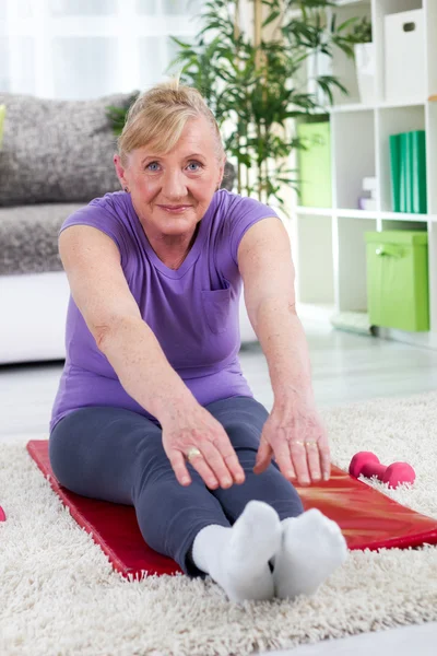 Oudere vrouw die thuis traint — Stockfoto