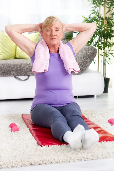 Senior woman exercising in home gym — Stock Photo, Image