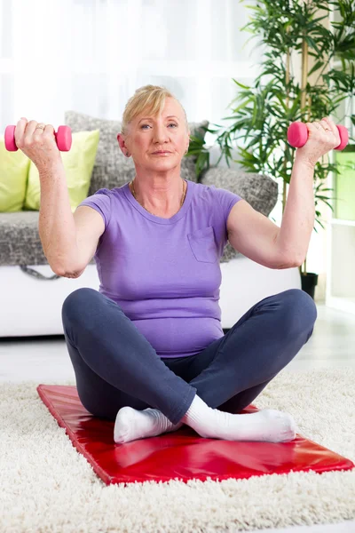 Mujer mayor ejercicio con pesas en casa — Foto de Stock
