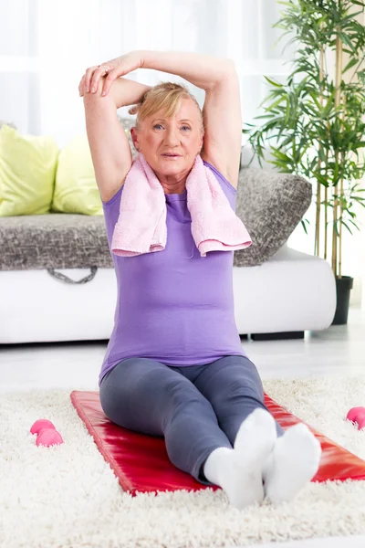 Senior woman doing stretching exercises — Stock Photo, Image