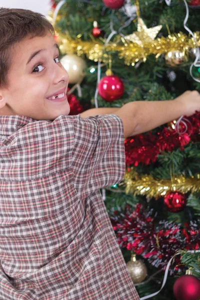 Menino feliz decorando a árvore de Natal — Fotografia de Stock