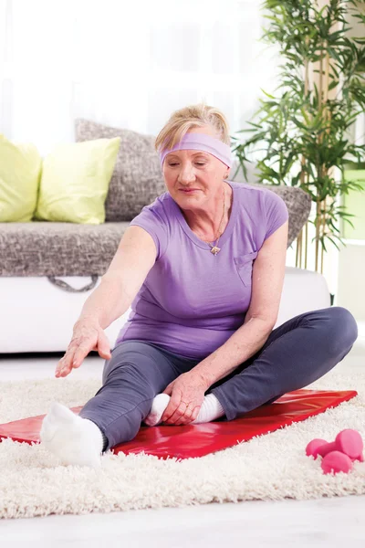 Donna anziana che esercita in palestra a casa — Foto Stock