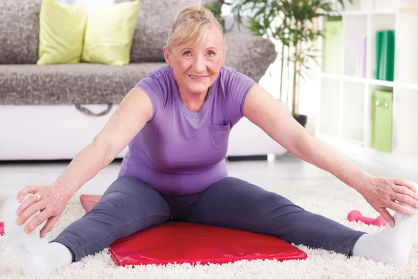 Äldre kvinna stretching och träning hemma — Stockfoto