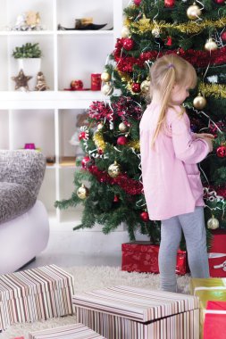 küçük bir kız evde Noel ağacı süsleme