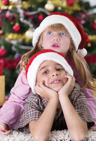 Portrait of happy boy laughing in his sister embrace on Christma — Stock Photo, Image