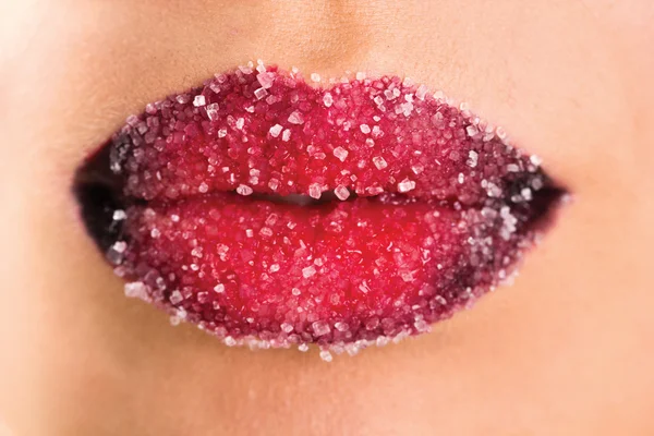 Woman's red lips coated with scattered sugar — Stock Photo, Image