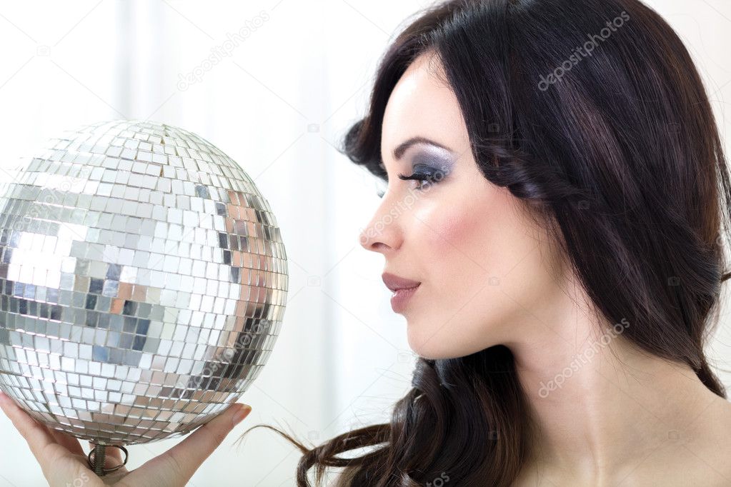 Beautiful young woman holding disco ball