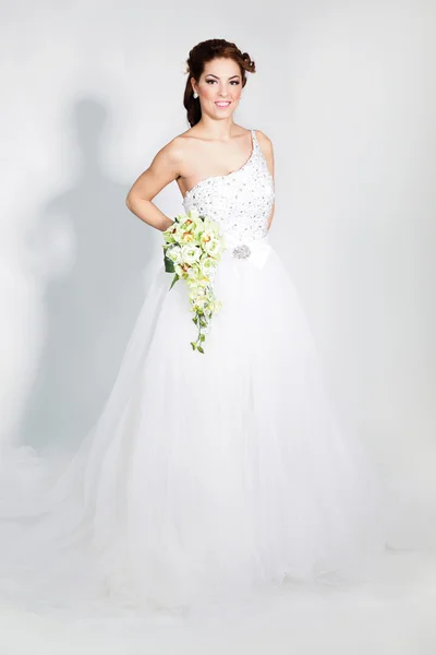 Szép elegáns menyasszony a fehér menyasszonyi ruha pózol — Stock Fotó