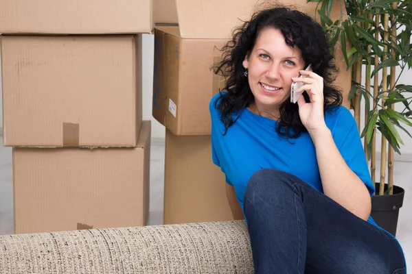 Young woman in the new home using a mobile phone — Stock Photo, Image
