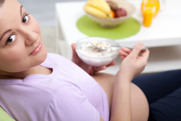 Vackra gravid flicka äter frukost — Stockfoto