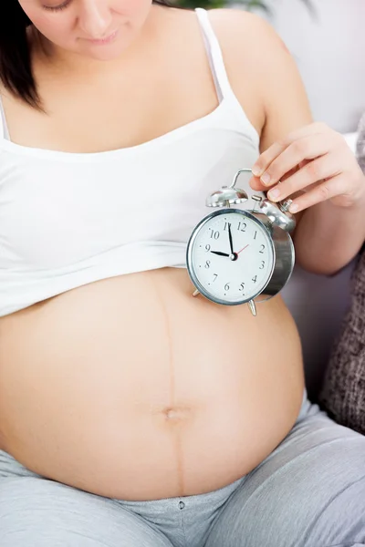 Dags för baby, gravid kvinna med klocka — Stockfoto