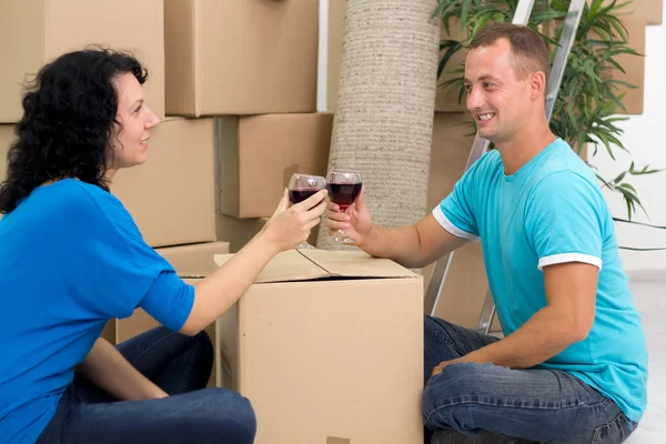 Casal feliz comemorando a mudança para casa nova com champanhe — Fotografia de Stock