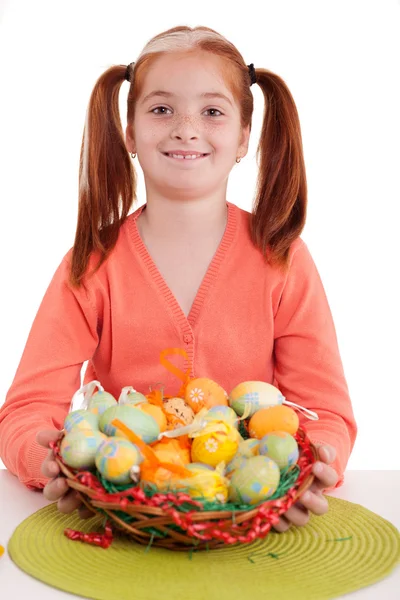 Smiling young girl holding easter eggs basket — Stock Photo, Image