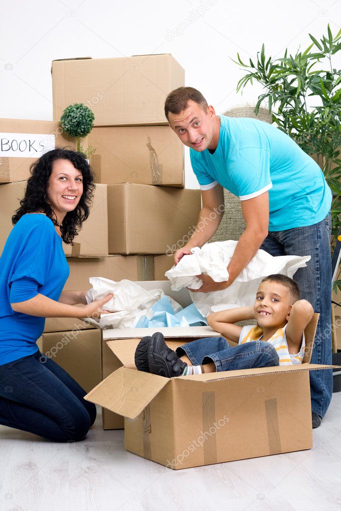 Family, parents, son, unpacking boxes and moving into a new home