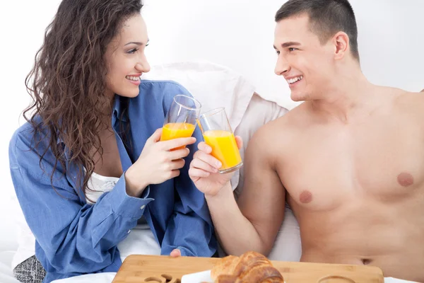 Vackra unga par med frukost i sängen tillsammans — Stockfoto