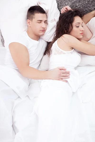 Beautiful young couple sleeping together in bed, the man embrace — Stock Photo, Image