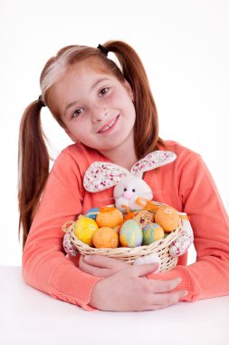 Paskalya yumurtaları sepeti tutan genç gülümseyen çilli kız