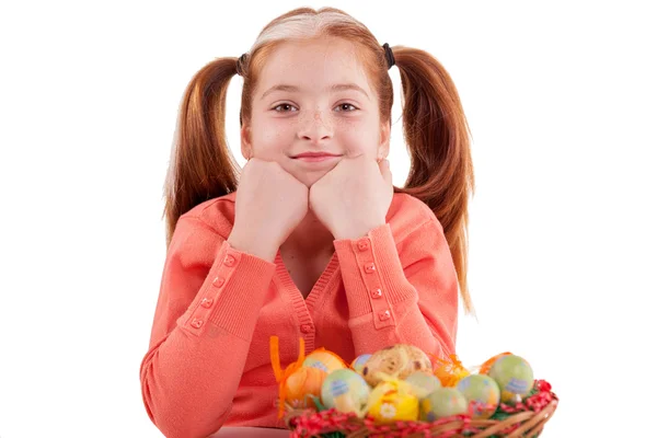 Funny girl with freckles and pigtails and a basket of Easter egg — Stock Photo, Image