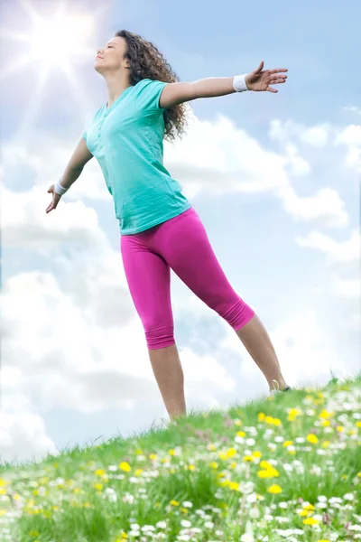 Schöne Frau genießt Gänseblümchenfeld und blauen Himmel — Stockfoto