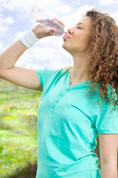 Retrato de una joven hermosa mujer bebiendo agua en verano gree — Foto de Stock