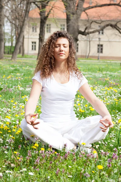 Attractive young woman in a lotus position — Stock Photo, Image