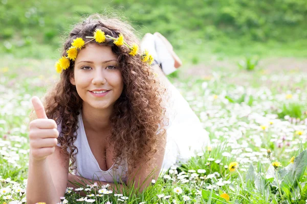 Menina bonita nova que coloca no campo de flores da margarida, ao ar livre — Fotografia de Stock