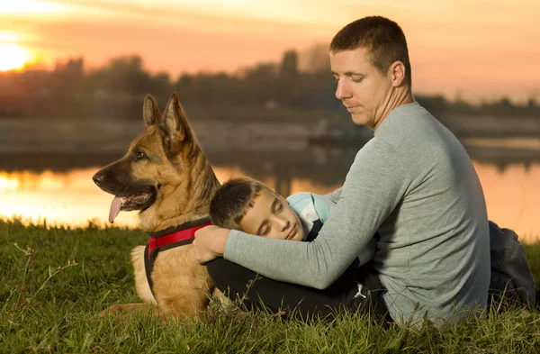 Portrait d'un bel enfant, père et chien au coucher du soleil — Photo