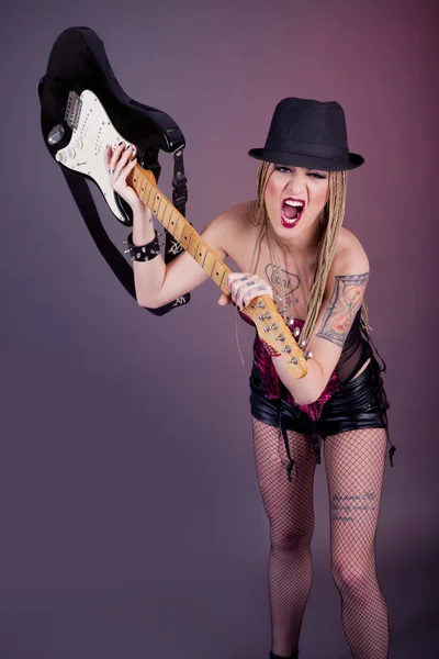 Jeune femme agressive avec tatouage fracassant guitare — Photo