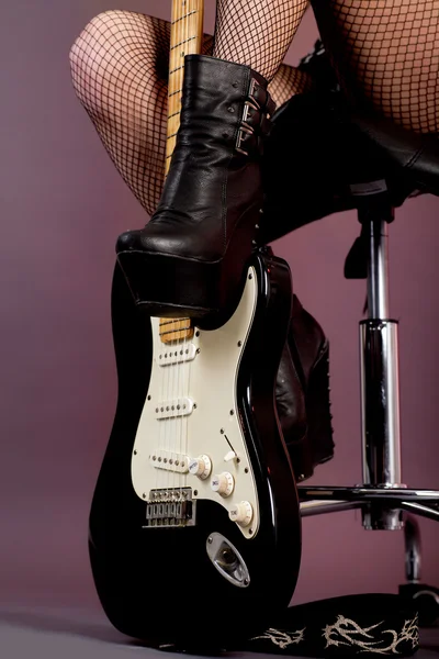 Funky young woman with her black hot guitar — Stock Photo, Image