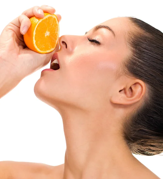 Young beautiful woman squeezes orange on white bacground — Stock Photo, Image