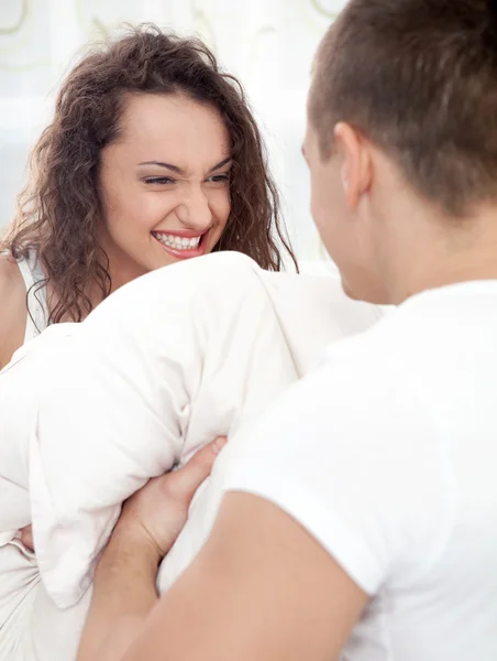 性感的年轻夫妇，有枕头战斗在卧室里 — 图库照片