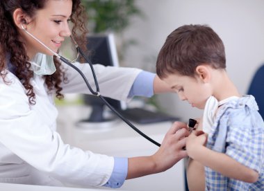 genç gülümseyen samimi kadın doktor küçük bir çocuk incelenmesi