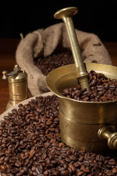 Coffee beans and old brass cup — Stock Photo, Image