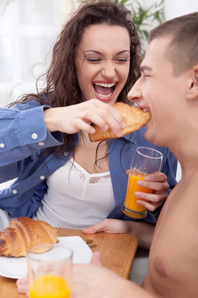 Belo jovem casal tomando café da manhã na cama juntos — Fotografia de Stock