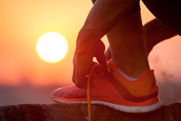 Mujer atando cordones de zapatos al aire libre — Foto de Stock