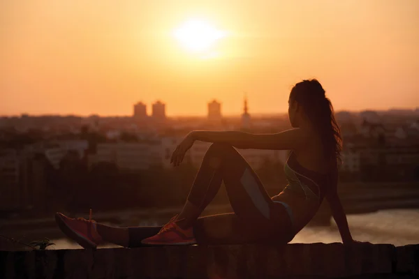 Спортивная женщина отдыхает и наслаждается закатом после тяжелой войны — стоковое фото