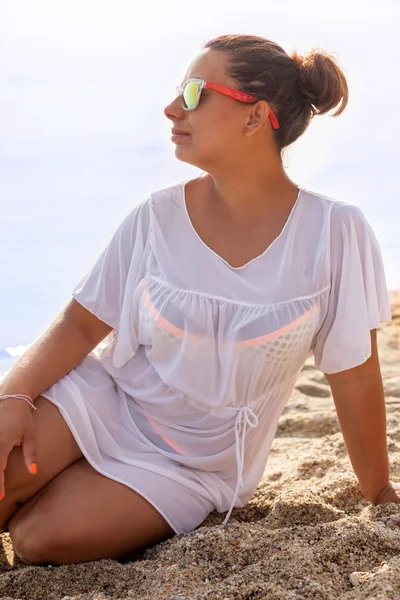 Lachende mooie vrouw op een strand met zonnebril — Stockfoto