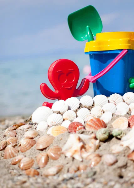 Child's bucket, spade and other toys on tropical beach against b — Stock Photo, Image